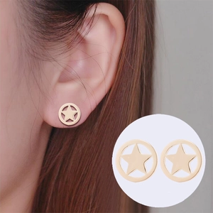Detailed close-up of a golden hollow star-shaped stud earring worn on earlobe