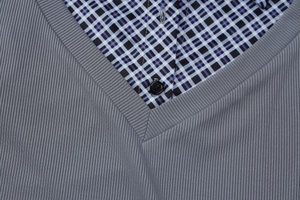 Détail du col polo à carreaux bleus et de l'encolure en V grise en tricot