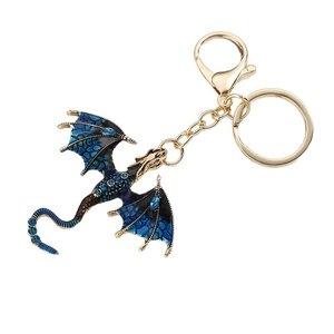 Vintage gold western dragon keychain with blue enamel and rhinestones on white background