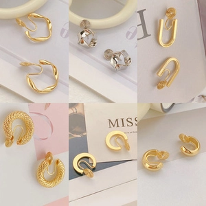 Detailed close-up of various gold and silver clip-on earrings in geometric styles