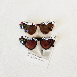 Kids heart-shaped Halloween sunglasses with Trick or Treat letters and bat castle charms
