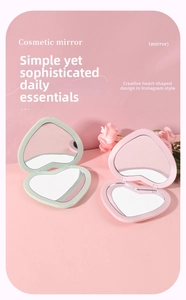 Detail view of heart-shaped folding cosmetic mirrors in pastel pink and mint green