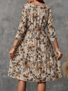 Elegant beige midi dress with orange floral print showing back view and tailored fit