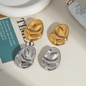 Detailed view of high-polished liquid metal geometric earrings in gold and silver finish