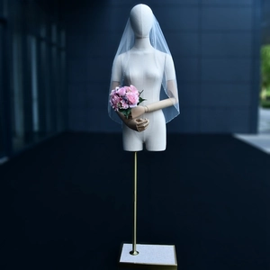 Detail of white bridal veil with sequin edges and light mesh texture on a mannequin