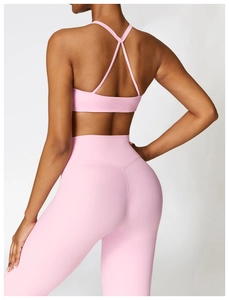 Pink high-waisted yoga set with cross-back sports bra and leggings seen from the back