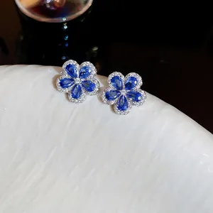Silver flower stud earrings with blue zirconia petals and micro-paved crystal accents