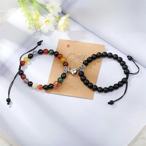 Détail de bracelets de couple en oeil de tigre avec fermoirs cœur aimantés et corde tressée