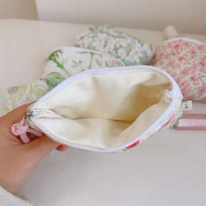 Close-up of floral mini cotton storage pouch with pink zipper and soft inner lining