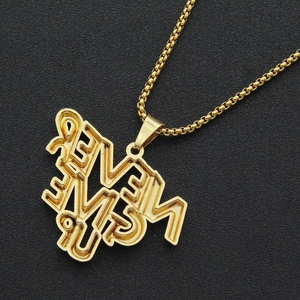 Close-up of golden hip hop triple layer letter pendant with iced out diamond details