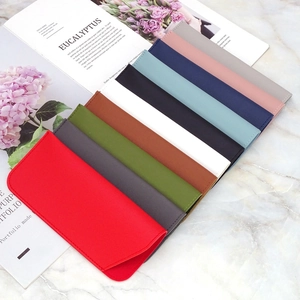 Detailed view of colorful PU leather eyeglass pouches in multiple colors on marble surface