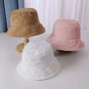 Chic winter rabbit fur bucket hats in brown pink and white on wooden display stands