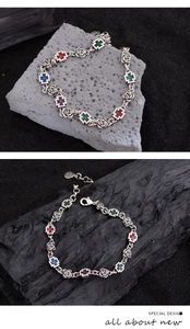 Detailed close-up of retro silver cross bracelet with rose links and colorful crystals