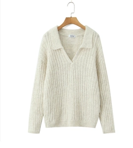 Close-up of cream knit sweater showing polo collar and vertical ribbed texture