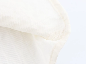 Vue macro détaillée de la texture du tissu en maille blanche et de la finition passepoilée