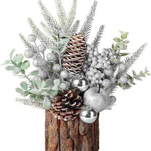 Artificial tabletop Christmas tree with silver berries and pine cones in a wooden base