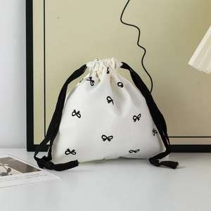 Detail of canvas drawstring pouch with black bow prints and thick cotton ropes