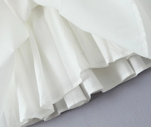Vue macro de l'ourlet plissé blanc avec coutures fines et détails de tissu à volants