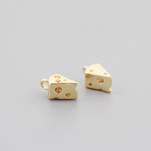 Macro detail of two 18K gold plated cheese shaped pendants with realistic hole textures
