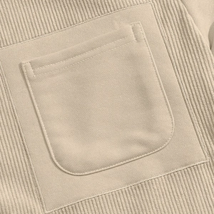 Detailed close-up of beige waffle knit fabric and stitching on a men's crewneck sweatshirt