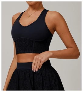 Detail of black yoga bra with floral lace trim and matching mini skirt set