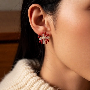 Detail of red floral zircon earring on model with elegant 18k gold plated finish