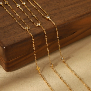 Luxurious gold-plated titanium anklets with clear zircons and cross charm on wood