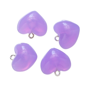 Detail of four translucent purple heart pendants with silver loops on white background