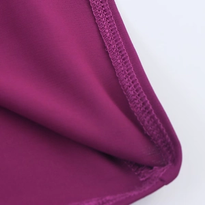 Vue détaillée de la couture et du tissu en maille violette sur la robe longue dos nu
