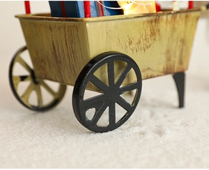Gros plan d'un traîneau vintage en métal jaune avec lumières LED et boîtes de cadeaux