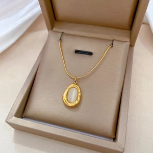 Minimalist gold titanium steel necklace with irregular cat eye stone pendant in a box