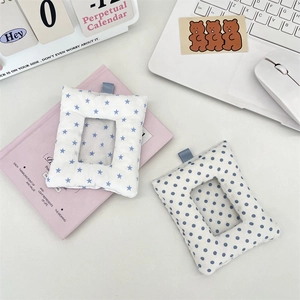 Close-up of padded cotton photo card holders with blue star and dot prints on pink desk