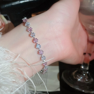 Close-up of star-cut pink and white cubic zirconia flower bracelet on a wrist