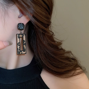 Gros plan de boucles d'oreilles léopard géométriques avec texture en métal martelé sur un mannequin