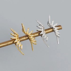 Macro view of gold and silver S925 sterling silver wing earrings with micro-set zircons
