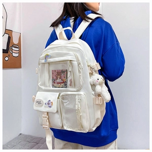 Side view of white multi-pocket backpack with cute cartoon patches and plush dog charm