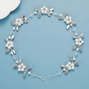 Detail of bridal hair vine with white pearls and crystals on silver wire over blue background
