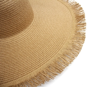 Close-up of the intricate weave and frayed fringe edge on a straw sun hat brim