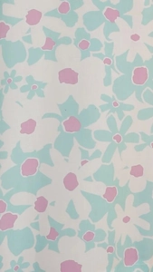 Detailed pattern of large daisy floral print in mint green, pink, and white textile fabric