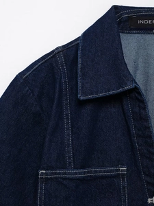Detail of reinforced double stitching and collar structure on indigo denim shirt