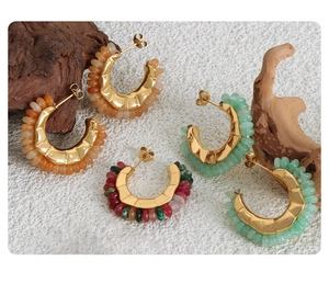 Detail of C-shaped vintage titanium steel hoop earrings with colorful natural stone beads