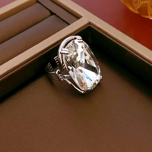Detailed close-up of a large emerald-cut crystal ring set in a silver textured band