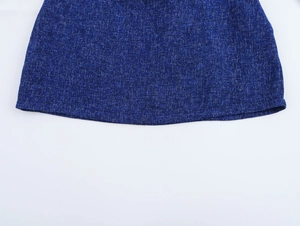 Detailed macro view of the dark blue tweed woven fabric hem with intricate knitting texture