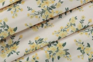 Gros plan détaillé du tissu floral avec de petites fleurs jaunes et feuilles vertes