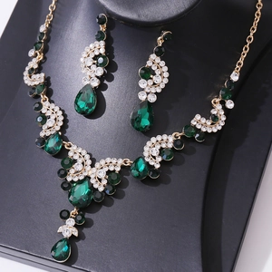 Detail of luxury bridal jewelry set with green teardrop gems and white crystals