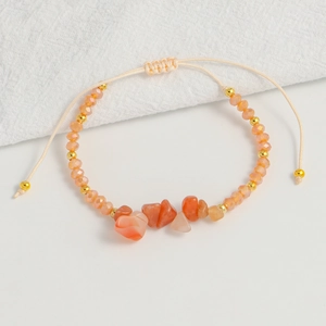 Detailed close-up of handmade Bohemian beaded bracelet with orange stones and gold spacers