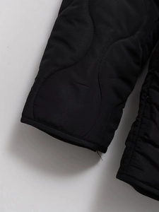Macro detail of black quilted jacket showing gourd stitching and nylon texture