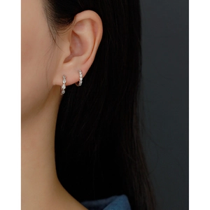 Detail view of s925 silver hoop earrings with water drop zircon on model's ear