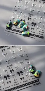 Close-up of M-899 butterfly and black lace nail stickers on marble texture nails