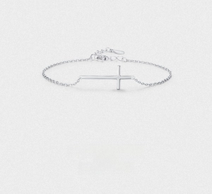 Detailed close-up of a minimalist silver cross bracelet with adjustable lobster clasp